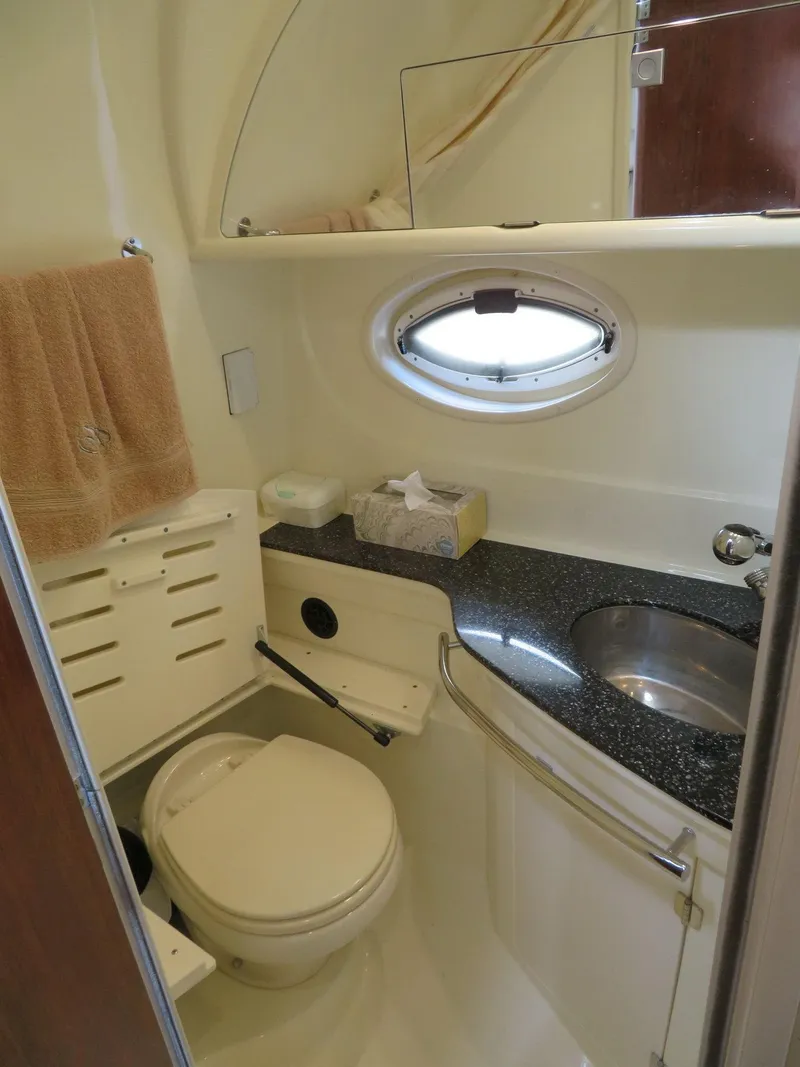 Slide: The Image of 2013 Monterey 340 Sport Yacht bathroom with porthole, sink, and toilet. - 17