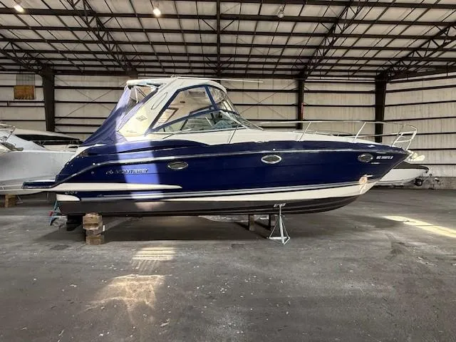 Slide: The Image of 2013 Monterey 340 Sport Yacht in a warehouse, blue and white exterior. - 24
