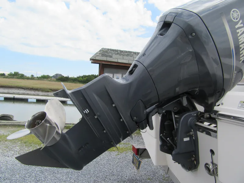 Slide: The Image of 2014 Robalo R200 Center Console with Yamaha outboard motor, docked near a wooden building. - 14