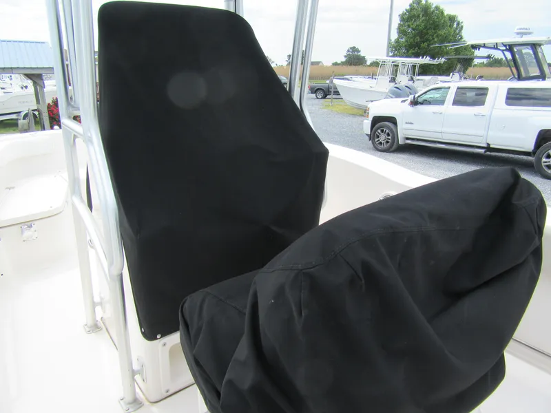 Slide: The Image of 2014 Robalo R200 Center Console boat with covered seats, parked outdoors. - 4