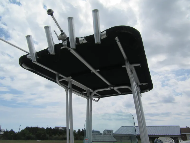 Slide: The Image of 2014 Robalo R200 Center Console T-top with rod holders against cloudy sky. - 6