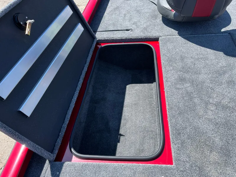 Slide: The Image of 2024 Ranger RT188 boat storage compartment with open lid, featuring carpeted interior and red trim. - 10