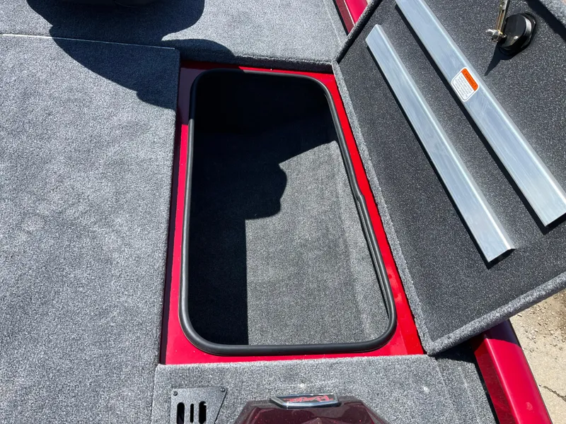 Slide: The Image of Open storage compartment on 2024 Ranger RT188 boat, featuring carpeted interior and red trim. - 9