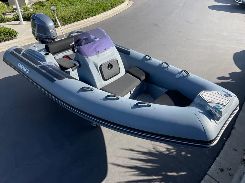 Slide: The Image of 2021 Brig Eagle 4 inflatable boat with outboard motor, parked on pavement. - 26