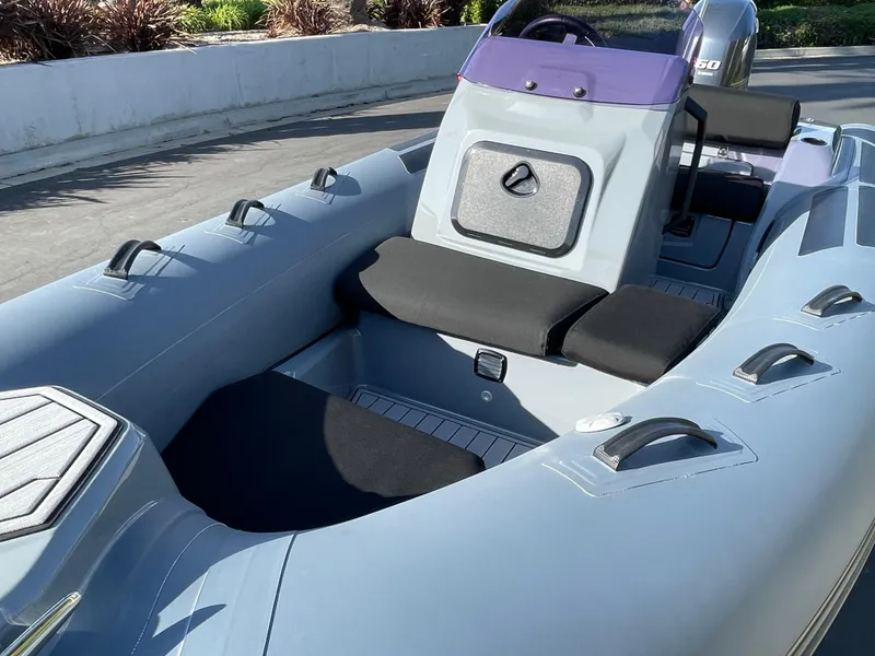 Slide: The Image of 2021 Brig Eagle 4 inflatable boat interior with seating and console, docked outdoors. - 31