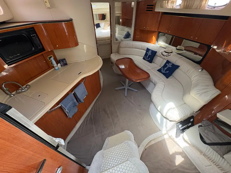 Slide: The Image of Luxurious interior of 1999 Sea Ray 380 Sundancer yacht with elegant seating and kitchenette. - 11