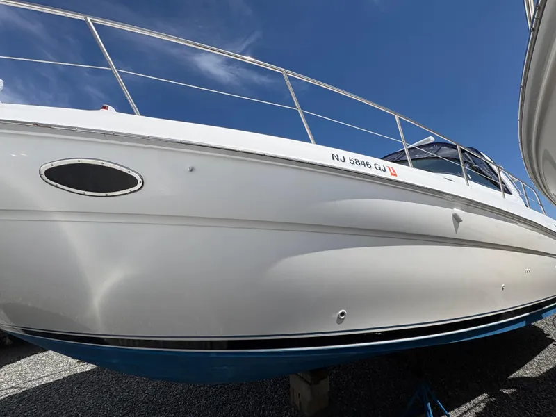 Slide: The Image of 1999 Sea Ray 380 Sundancer boat with white hull, docked under clear blue sky. - 2
