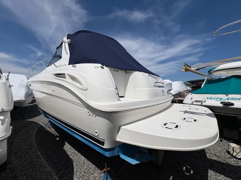 Slide: The Image of 1999 Sea Ray 380 Sundancer boat with blue cover, docked under clear sky. - 3