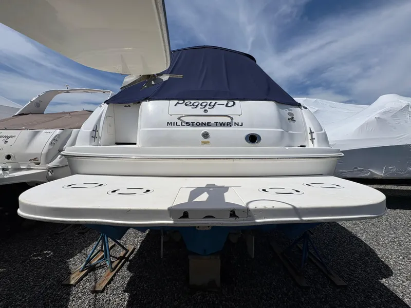 Slide: The Image of 1999 Sea Ray 380 Sundancer boat, rear view, docked, with blue cover and "Peggy-D" name. - 4