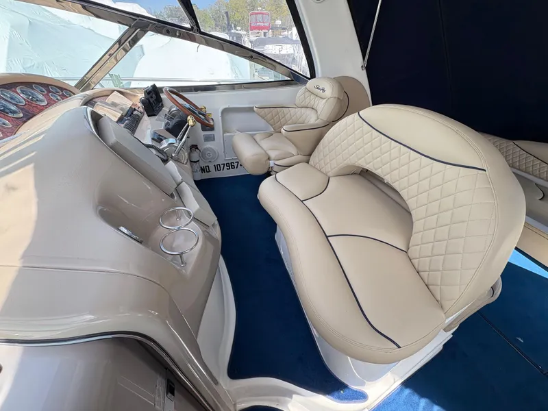 Slide: The Image of 1999 Sea Ray 380 Sundancer interior with beige leather seating and modern dashboard. - 5
