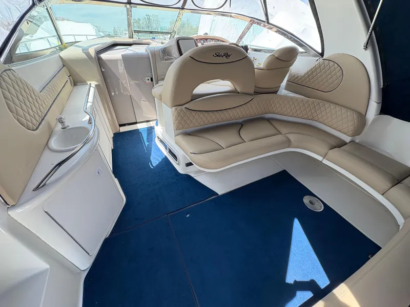 Slide: The Image of 1999 Sea Ray 380 Sundancer interior with beige seating and blue carpet. - 6
