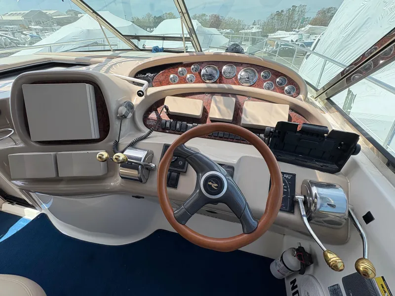Slide: The Image of 1999 Sea Ray 380 Sundancer helm with steering wheel, gauges, and controls. - 8