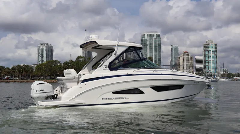 Slide: The Image of 2021 Regal 33 XO boat cruising near city skyline with Yamaha engine. - 11