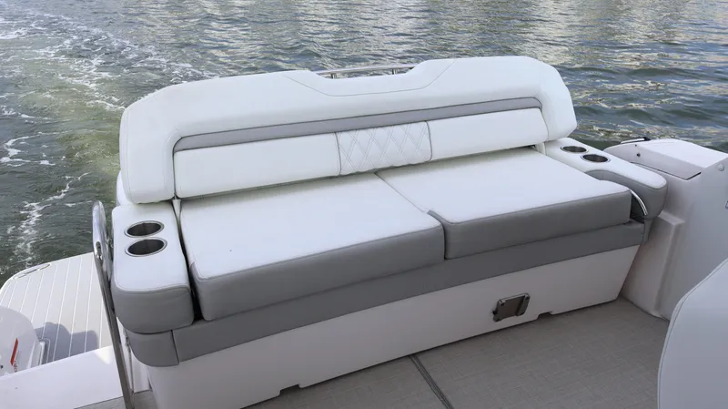 Slide: The Image of 2021 Regal 33 XO boat seating with cup holders on a calm water backdrop. - 14
