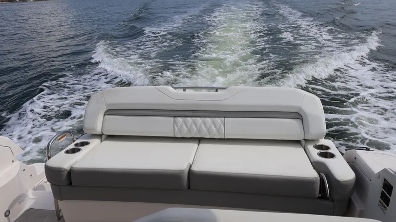 Slide: The Image of 2021 Regal 33 XO boat with cushioned seating, cruising on open water. - 15