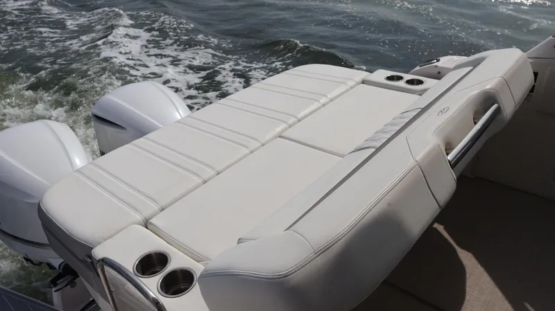 Slide: The Image of 2021 Regal 33 XO boat with white cushioned seating and cup holders, cruising on water. - 16