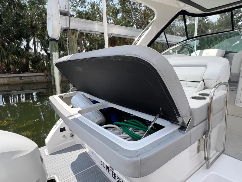 Slide: The Image of 2021 Regal 33 XO boat with open storage compartment, docked near water. - 19