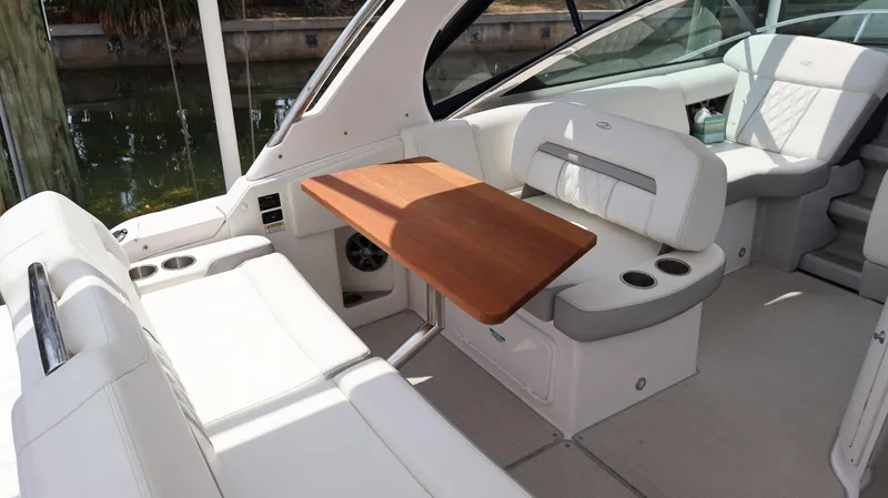 Slide: The Image of 2021 Regal 33 XO boat interior with white seating and wooden table. - 27