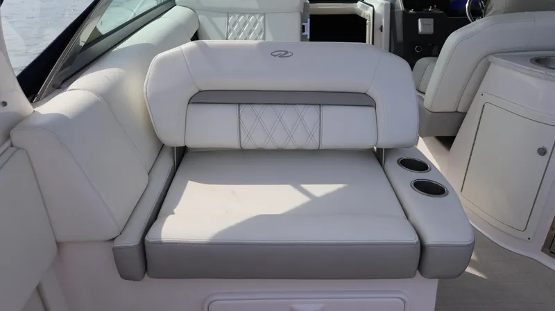 Slide: The Image of 2021 Regal 33 XO boat interior with white cushioned seating and cup holders. - 28
