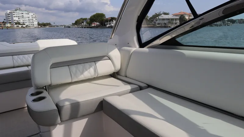 Slide: The Image of 2021 Regal 33 XO boat interior with white seating, overlooking a scenic waterfront. - 32