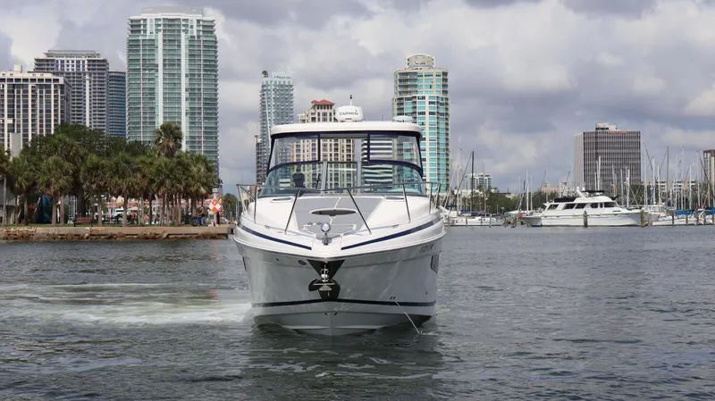 Slide: The Image of 2021 Regal 33 XO boat cruising in urban waterfront with skyscrapers in background. - 4