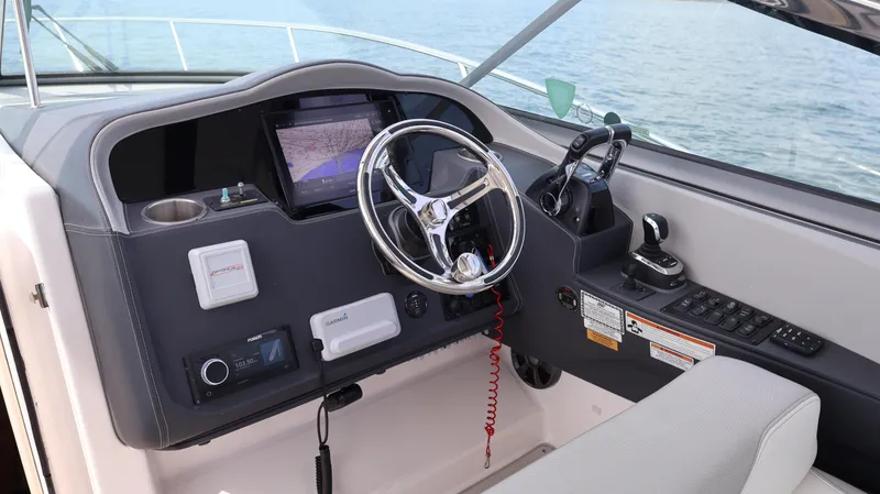 Slide: The Image of 2021 Regal 33 XO boat helm with steering wheel and navigation controls. - 41