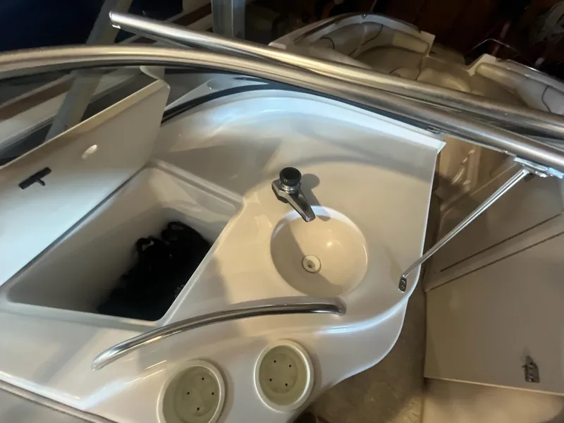 Slide: The Image of 2002 Ebbtide 2400 Mystique boat interior with sink and storage compartment. - 6