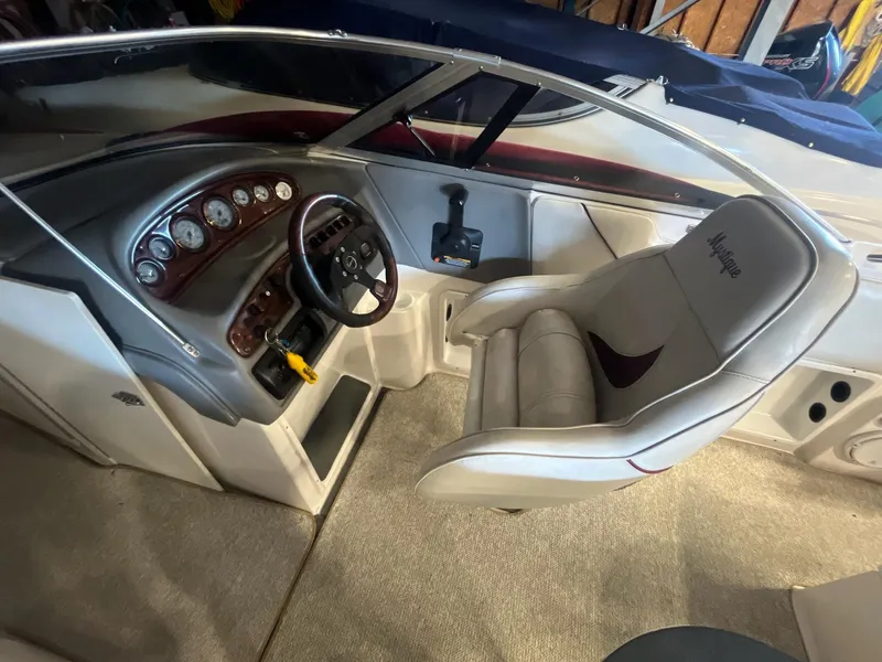 Slide: The Image of 2002 Ebbtide 2400 Mystique boat interior with steering wheel and dashboard controls. - 7