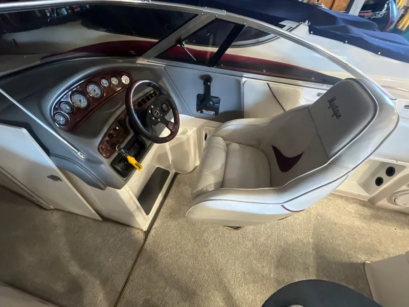 Slide: The Image of 2002 Ebbtide 2400 Mystique boat interior with steering wheel and dashboard controls. - 8