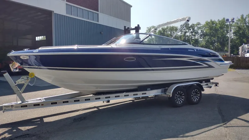 Slide: The Image of 2026 Formula 270 Bowrider boat on trailer, sleek design, parked outdoors. - 2