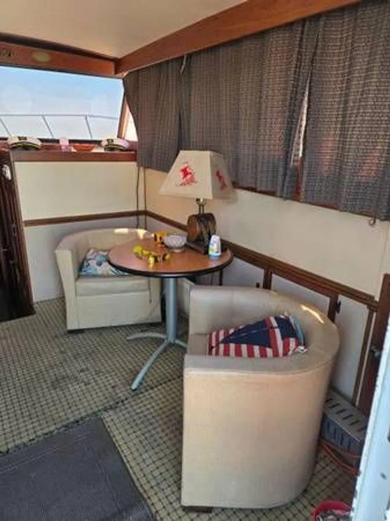 Slide: The Image of 1979 Viking Yacht interior with cozy seating, table, and nautical-themed decor. - 10