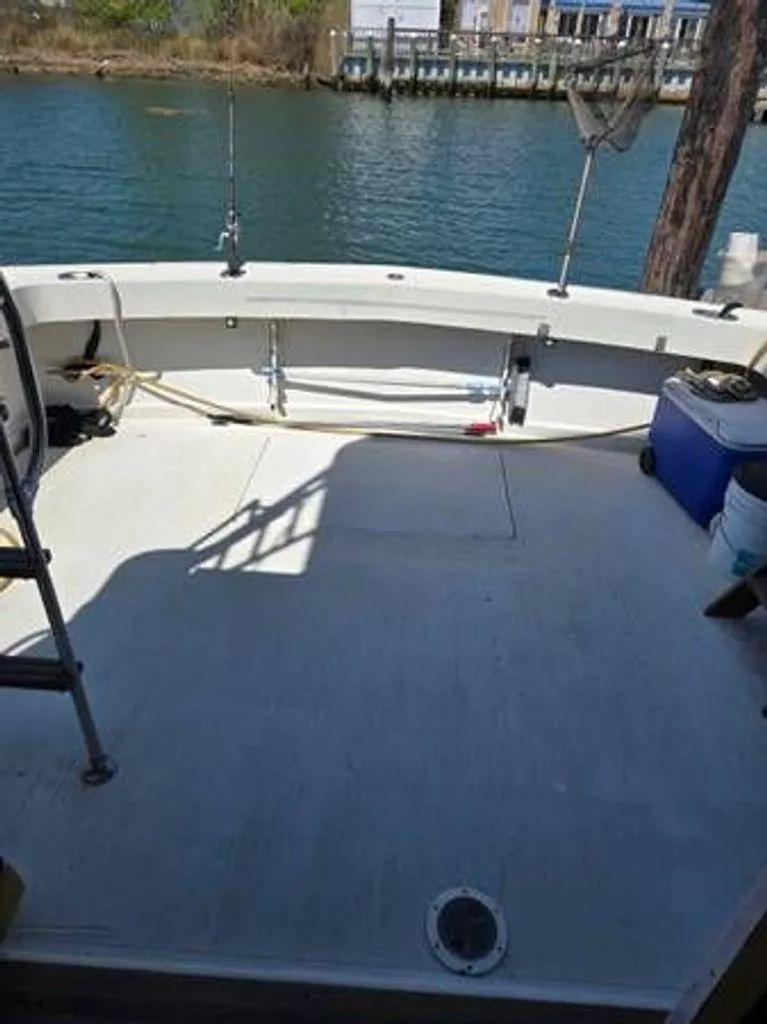 Slide: The Image of 1979 Viking Yacht deck with fishing rods and cooler by the water. - 5