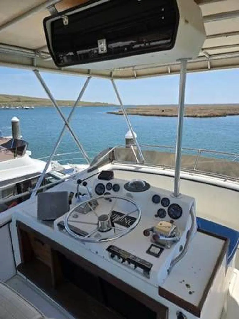 Slide: The Image of 1979 Viking Yacht helm with steering wheel, gauges, and open water view. - 7