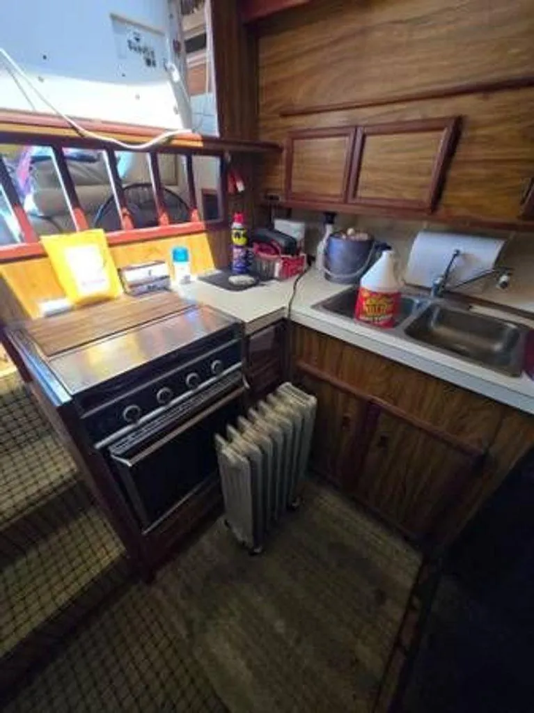 Slide: The Image of 1979 Viking Yacht kitchen with stove, sink, and wooden cabinets. - 8