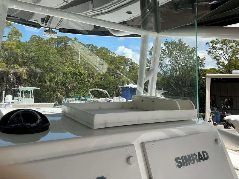Slide: The Image of 2017 Cape Horn 36 XS boat dashboard with Simrad equipment, surrounded by lush greenery. - 14