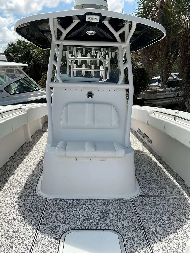 Slide: The Image of 2017 Cape Horn 36 XS boat interior with seating and console, surrounded by palm trees. - 20