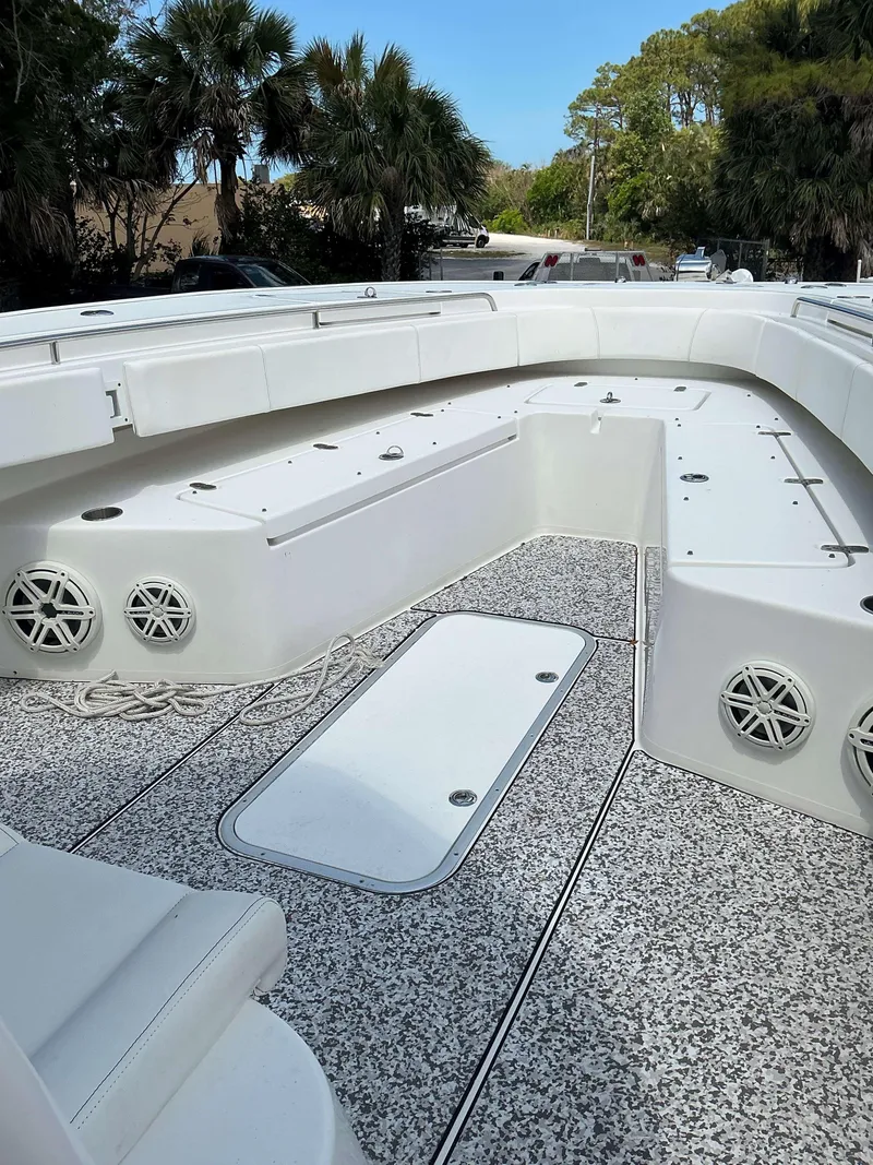 Slide: The Image of 2017 Cape Horn 36 XS boat interior with white seating and deck, surrounded by trees. - 6