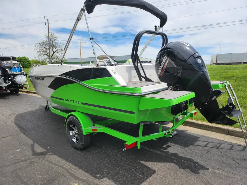 Slide: The Image of 2023 Starcraft SVX 191 OB boat, vibrant green and white, on trailer with outboard motor. - 3