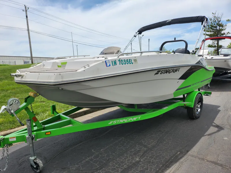 Slide: The Image of 2023 Starcraft SVX 191 OB boat on a green trailer, parked outdoors. - 5