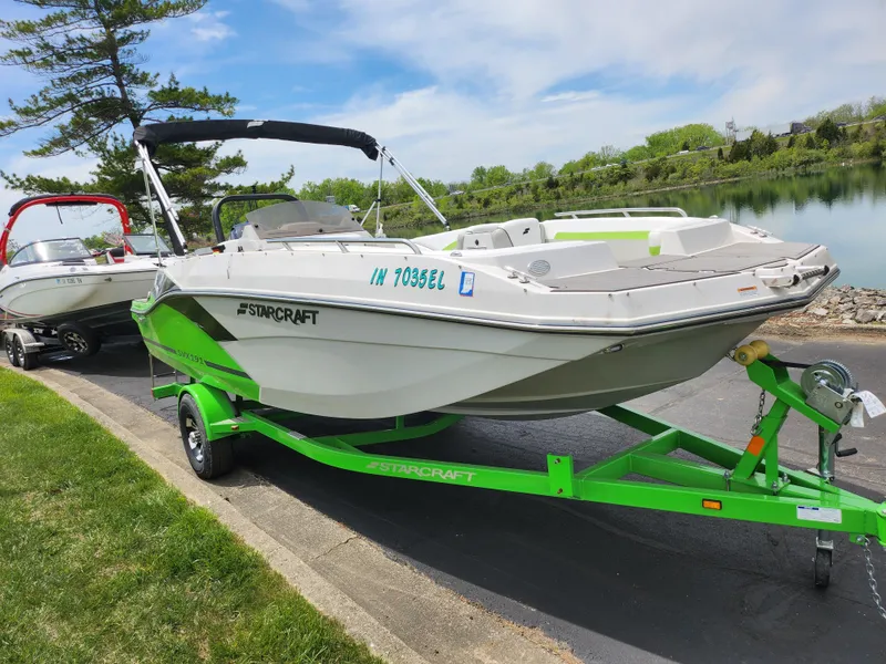 Slide: The Image of 2023 Starcraft SVX 191 OB boat on a vibrant green trailer by a lakeside. - 8