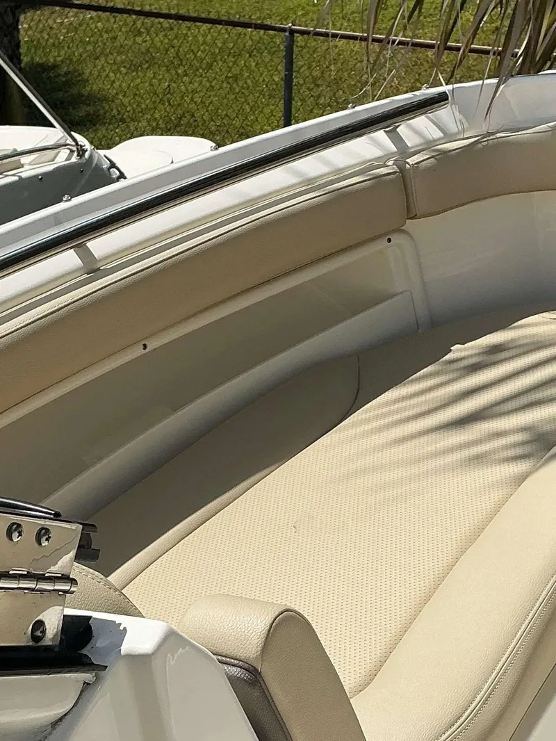 Slide: The Image of 2020 Pursuit DC 266 boat interior with beige seating and sleek design. - 10