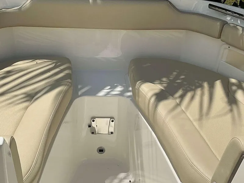 Slide: The Image of 2020 Pursuit DC 266 boat interior with beige cushioned seating. - 11