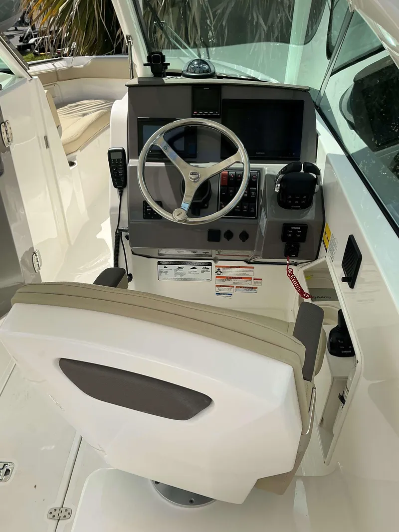 Slide: The Image of 2020 Pursuit DC 266 boat helm with steering wheel and control panel. - 12