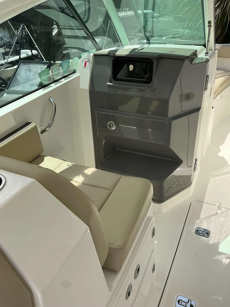 Slide: The Image of 2020 Pursuit DC 266 boat interior with beige seating and control panel. - 14