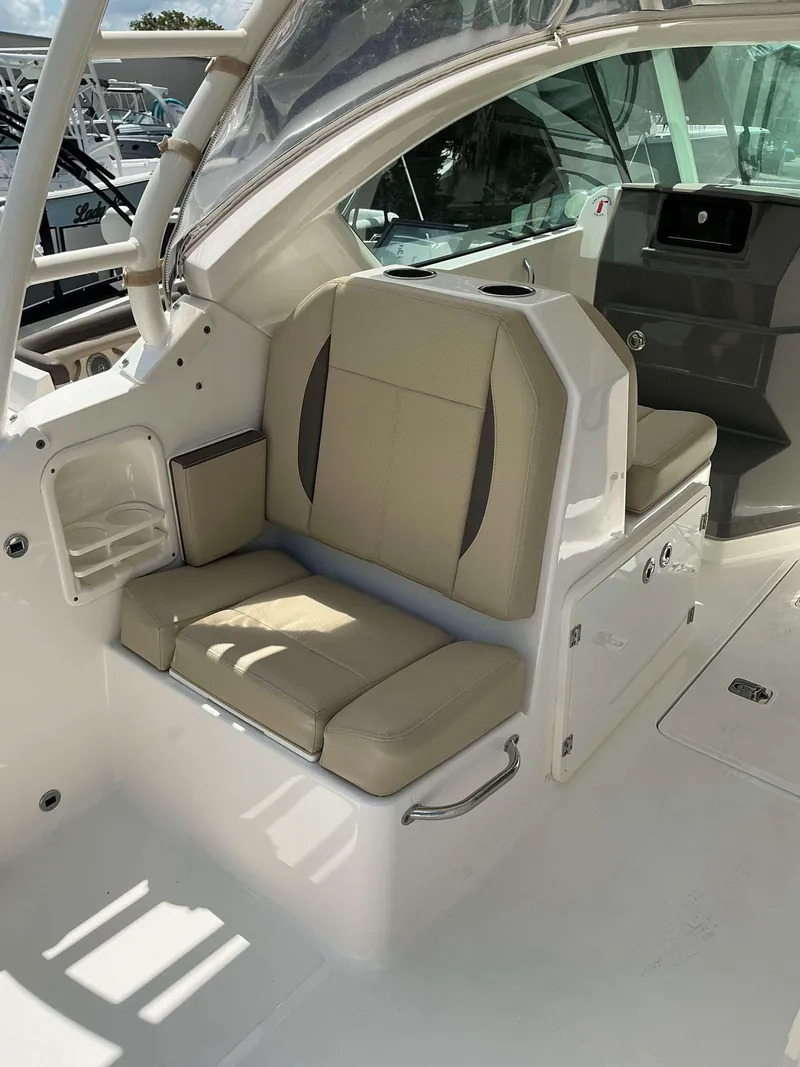Slide: The Image of 2020 Pursuit DC 266 boat interior with beige seating and modern design. - 3