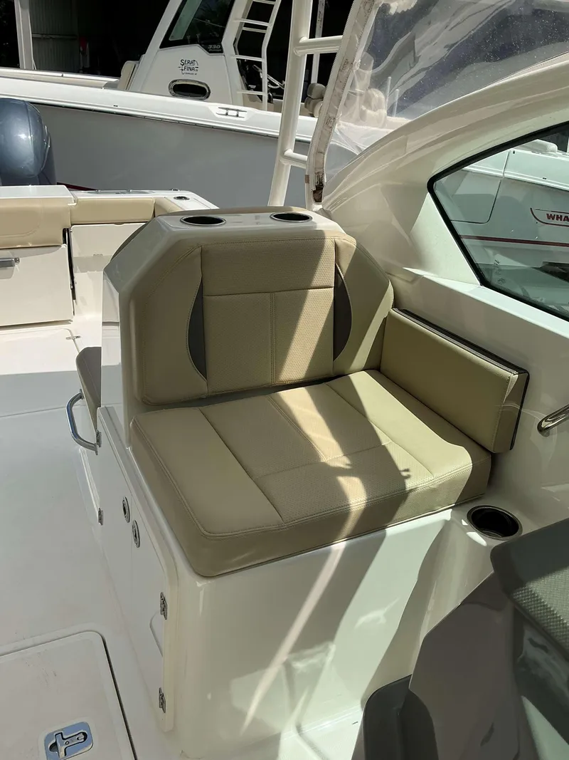 Slide: The Image of 2020 Pursuit DC 266 boat interior with beige seating and cup holders. - 6