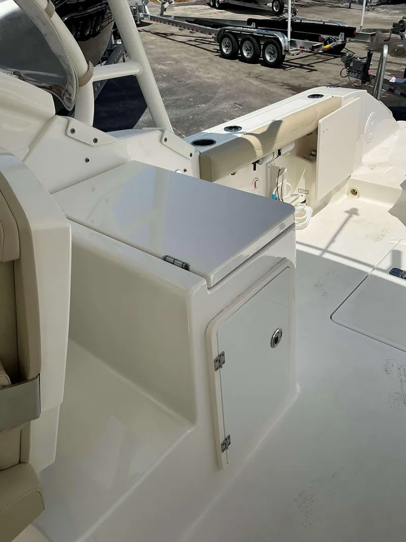 Slide: The Image of 2020 Pursuit DC 266 boat interior with storage compartment and seating area. - 7