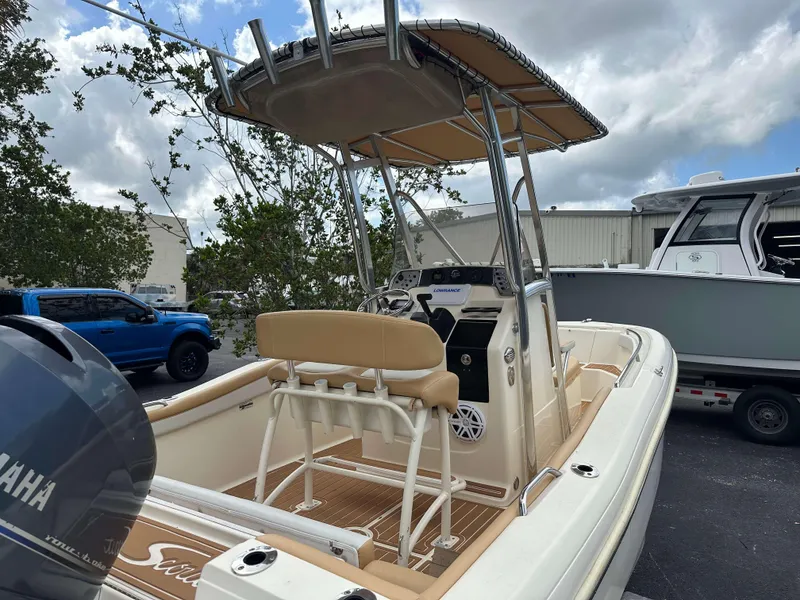 Slide: The Image of 2014 Scout 215 XSF boat with Yamaha engine, parked outdoors under cloudy sky. - 4