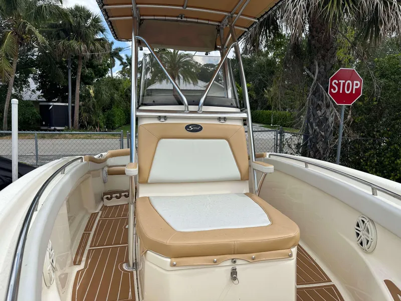 Slide: The Image of 2014 Scout 215 XSF boat interior with tan seating and stop sign in background. - 6