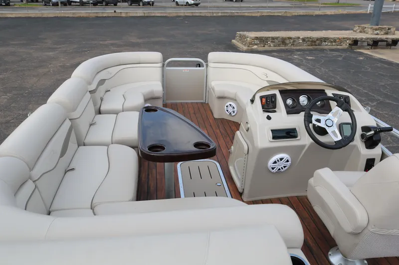 Slide: The Image of 2015 Bennington 22SSLDX pontoon boat interior with beige seating and wood accents. - 11